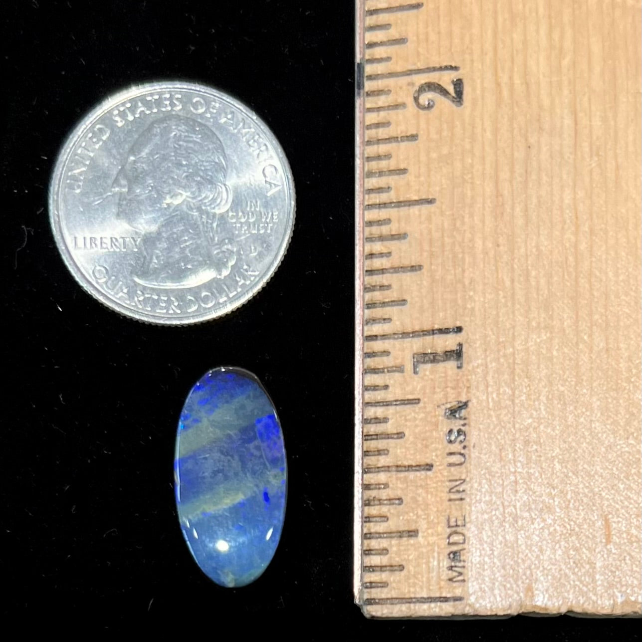 A loose, oval cabochon cut black boulder opal stone from Quilpie, Australia.