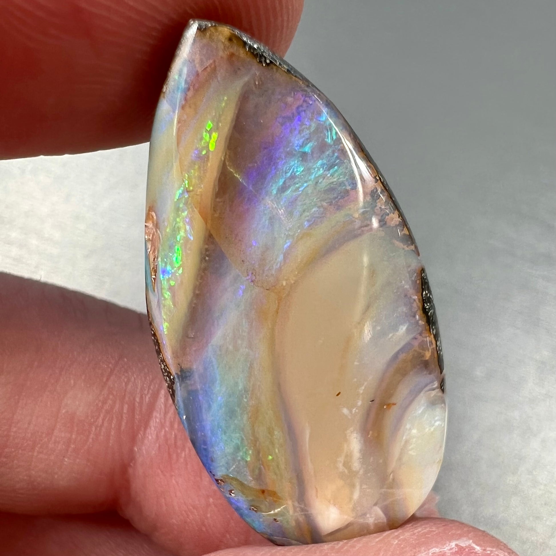 A loose, pear shaped cabochon cut boulder opal stone from Quilpie, Australia.