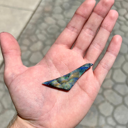 A loose, triangular shaped boulder opal stone from Queensland, Australia.
