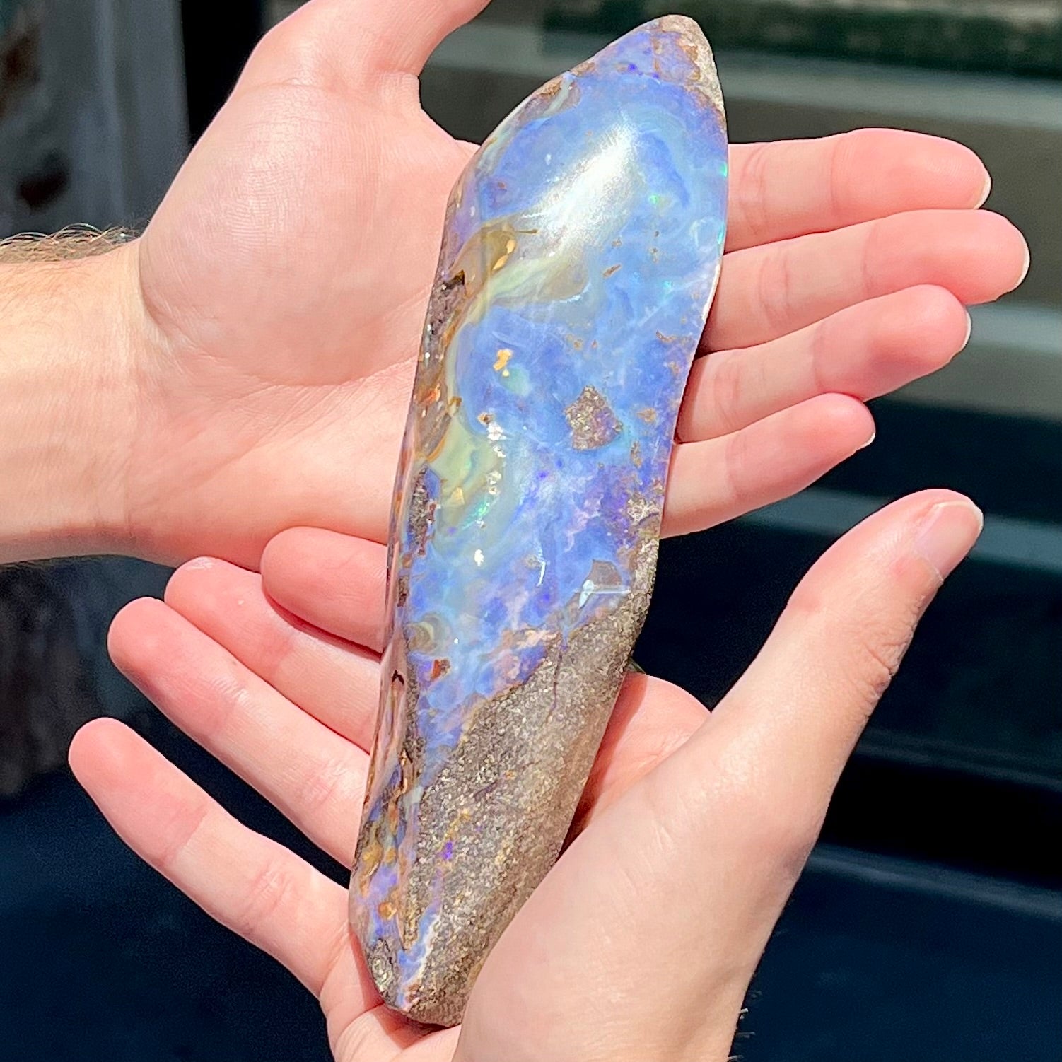 A 7 inch long polished blue Quilpie boulder opal specimen from Queensland, Australia.