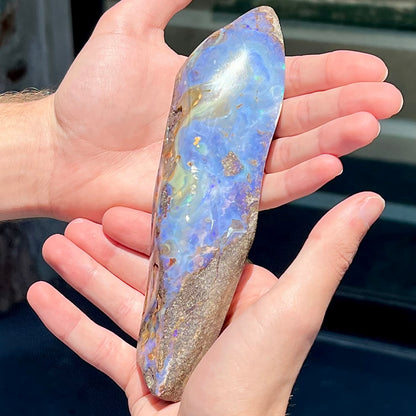 A 7 inch long polished blue Quilpie boulder opal specimen from Queensland, Australia.