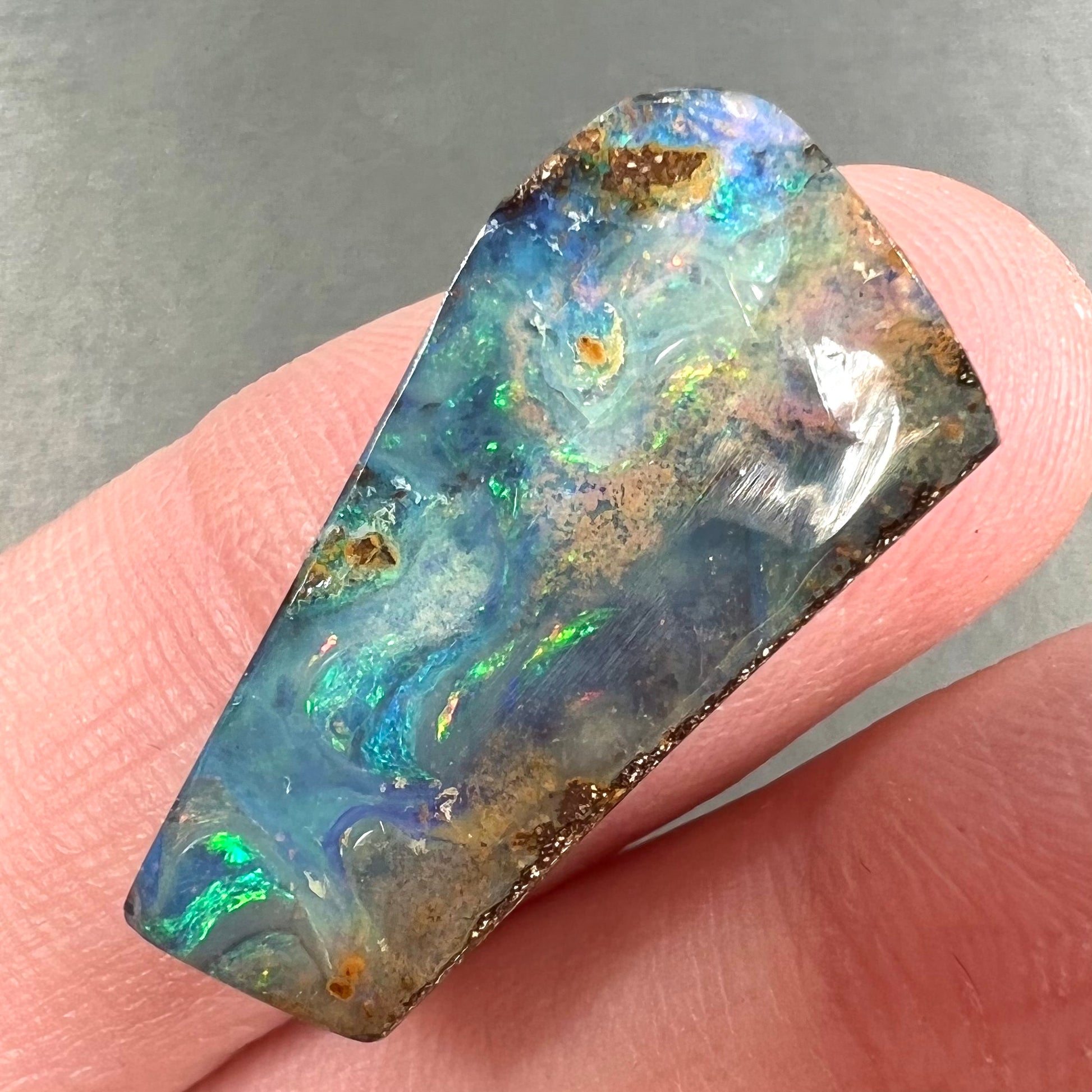 A loose, freeform cut boulder opal stone from Quilpie, Australia.