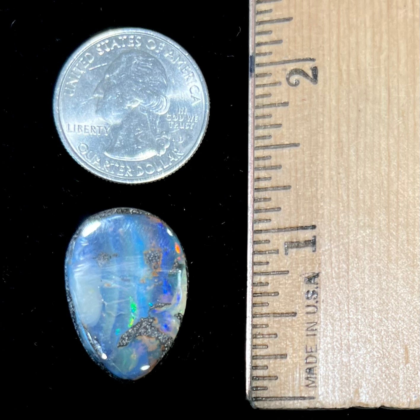 A loose, pear shaped Australian boulder opal.  The pattern on the opal resembles the face of a very sad man.