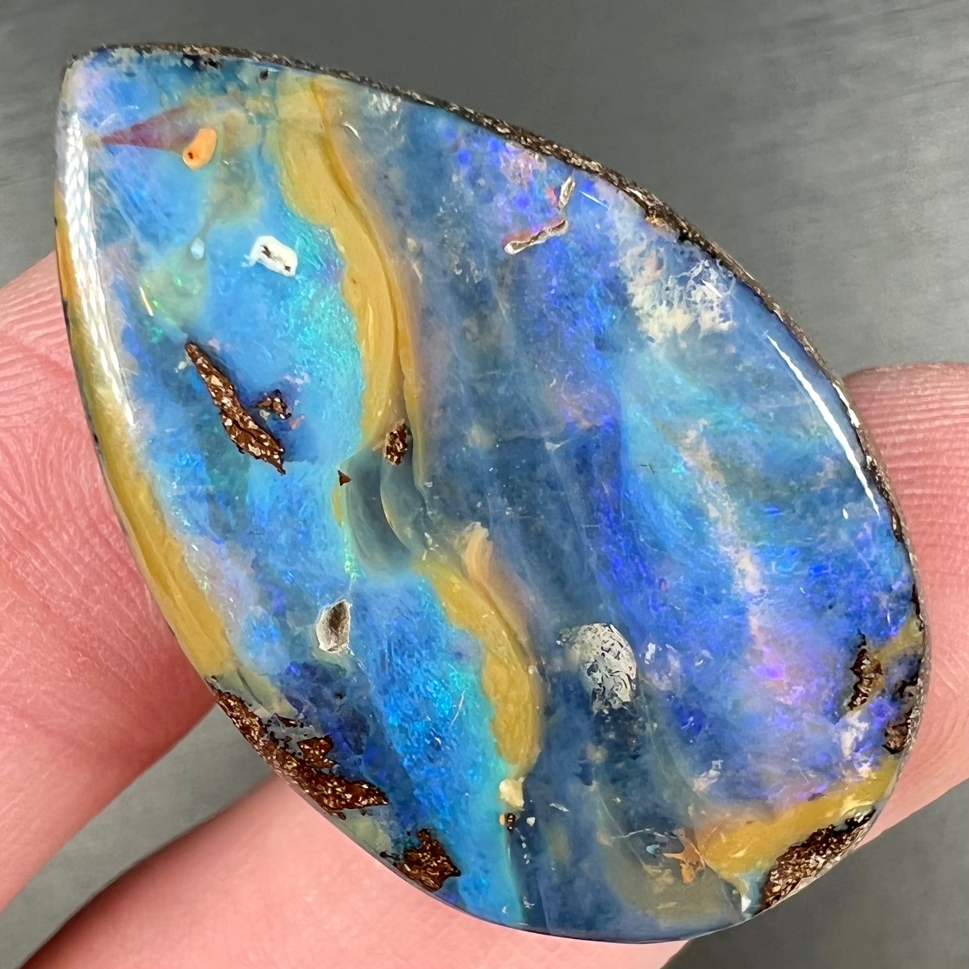 A loose, pear shaped cabochon cut boulder opal stone from Quilpie, Australia.