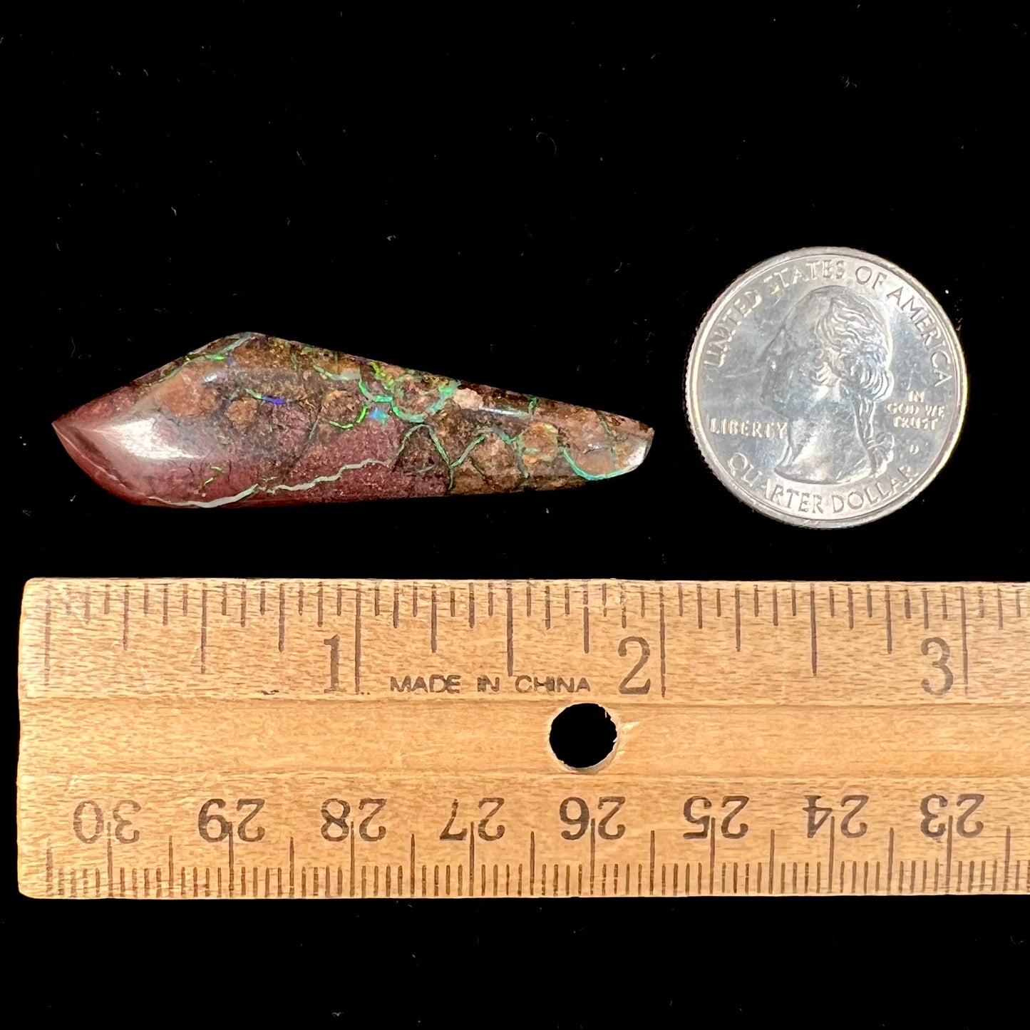 A loose, freeform cabochon cut Koroit boulder opal stone.