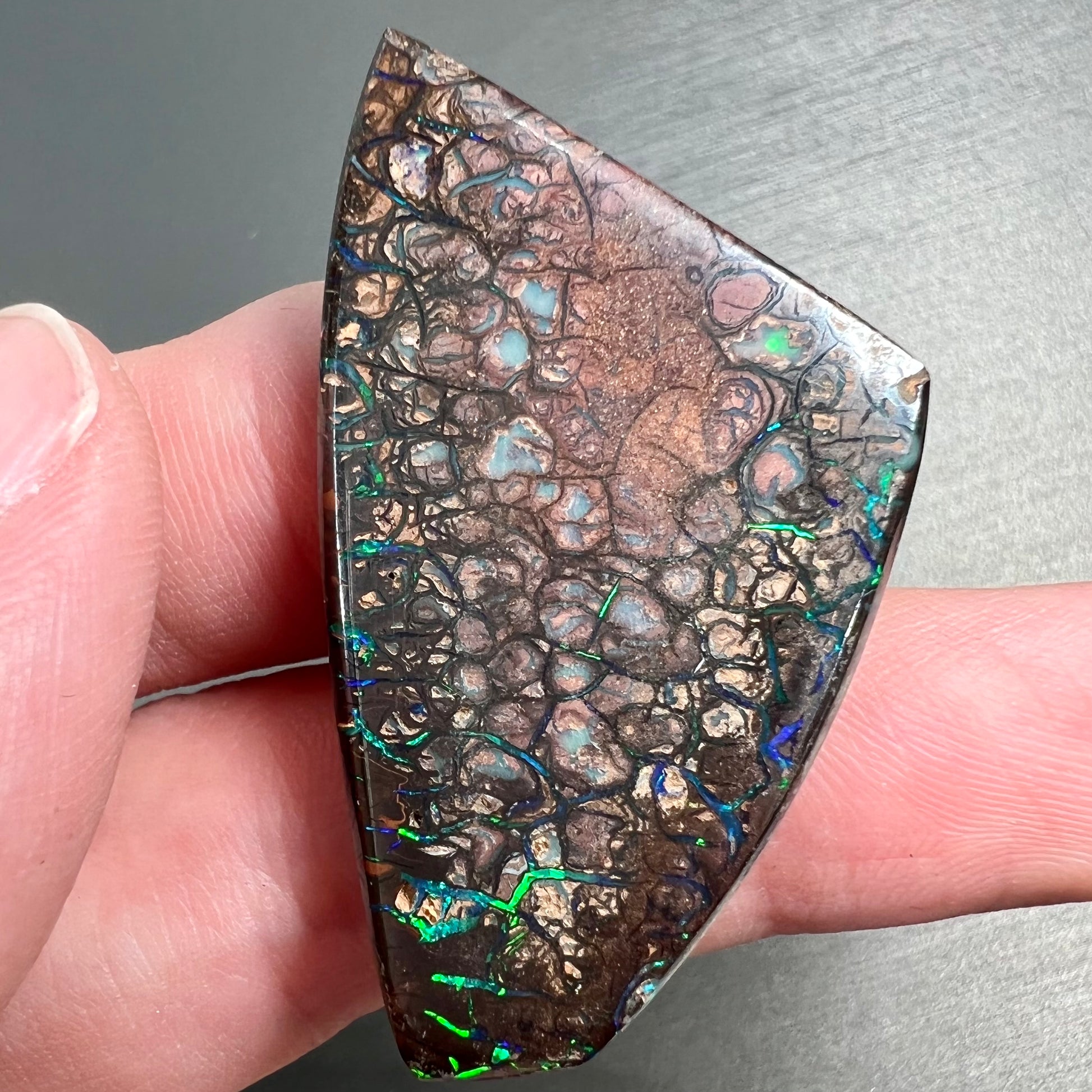 A loose, freeform cut polished Koroit boulder opal stone from Koroit Mining District, Australia.