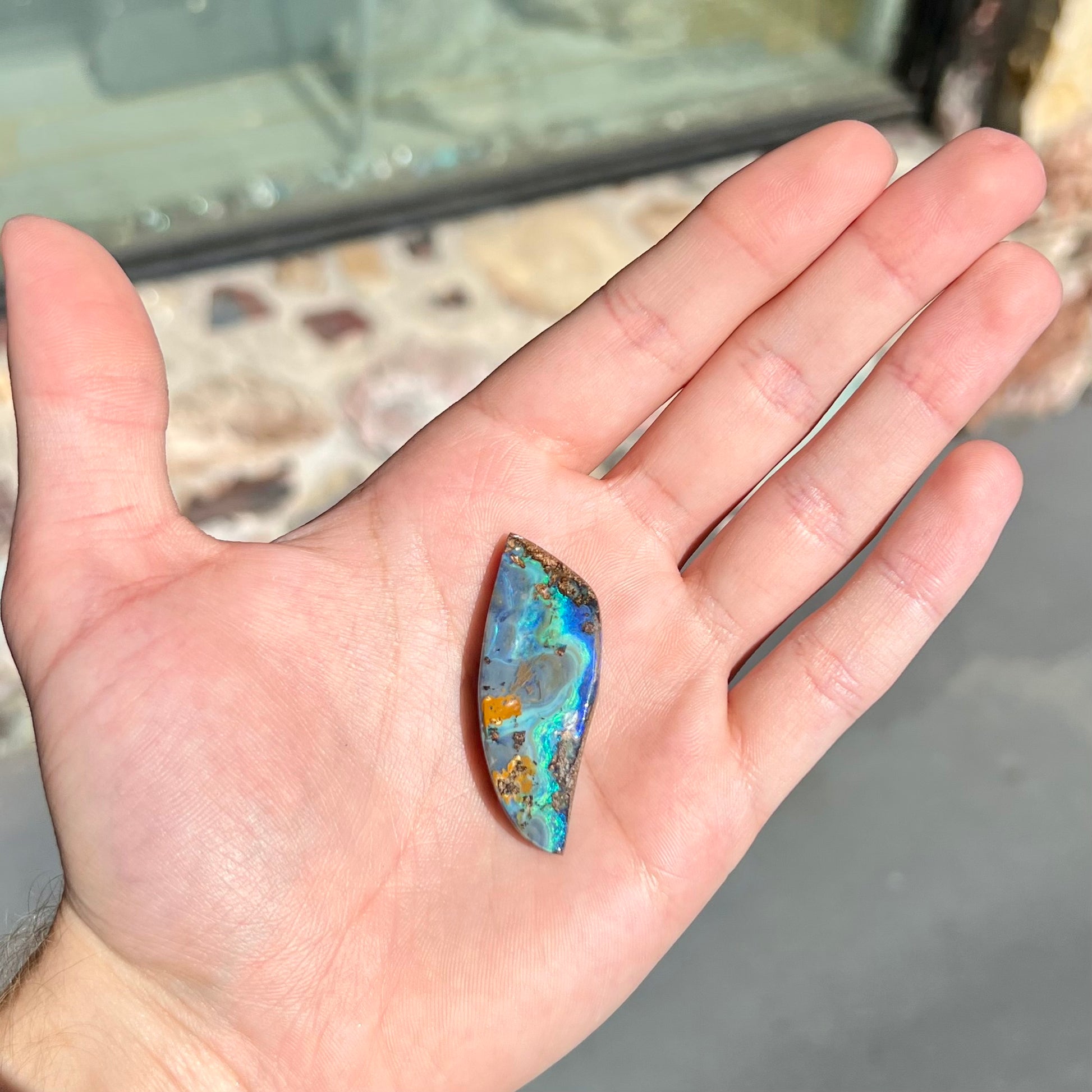 A freeform cut, loose black boulder opal stone from Queensland, Australia.