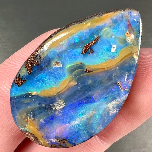 A loose, pear shaped cabochon cut boulder opal stone from Quilpie, Australia.