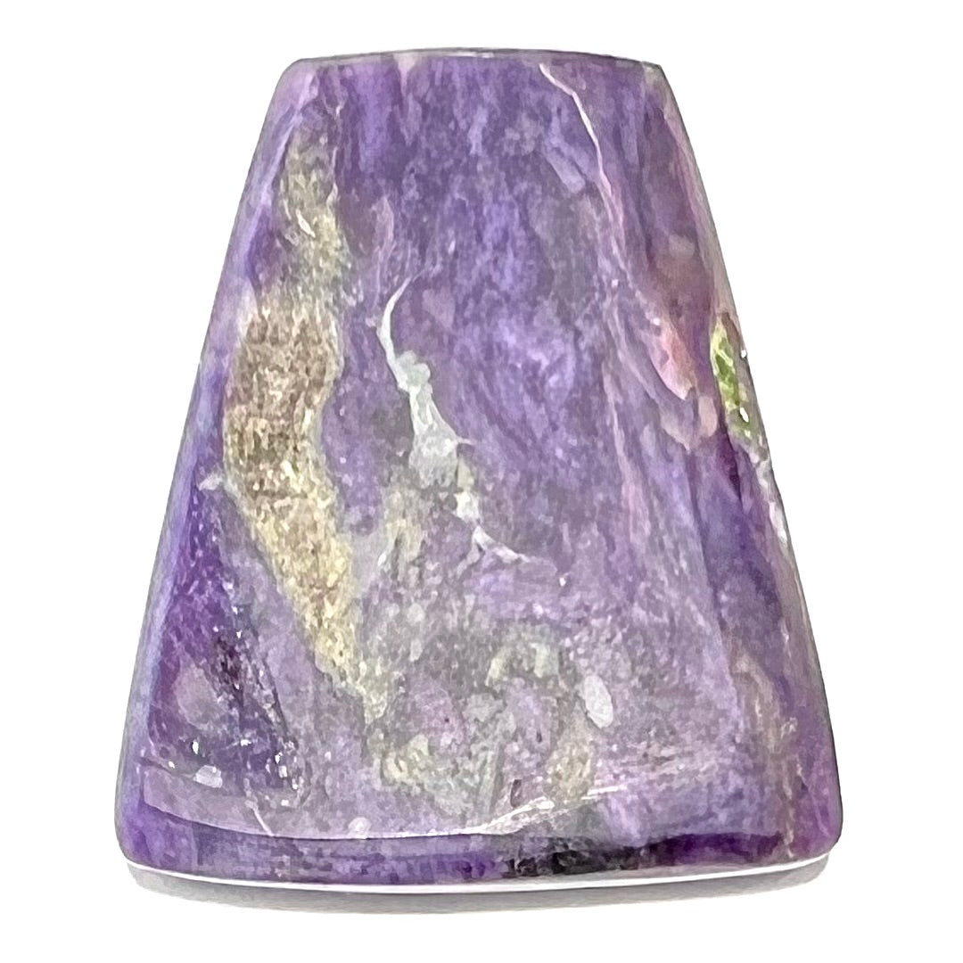 A loose, trapezoid cabochon cut purple charoite stone from Russia.