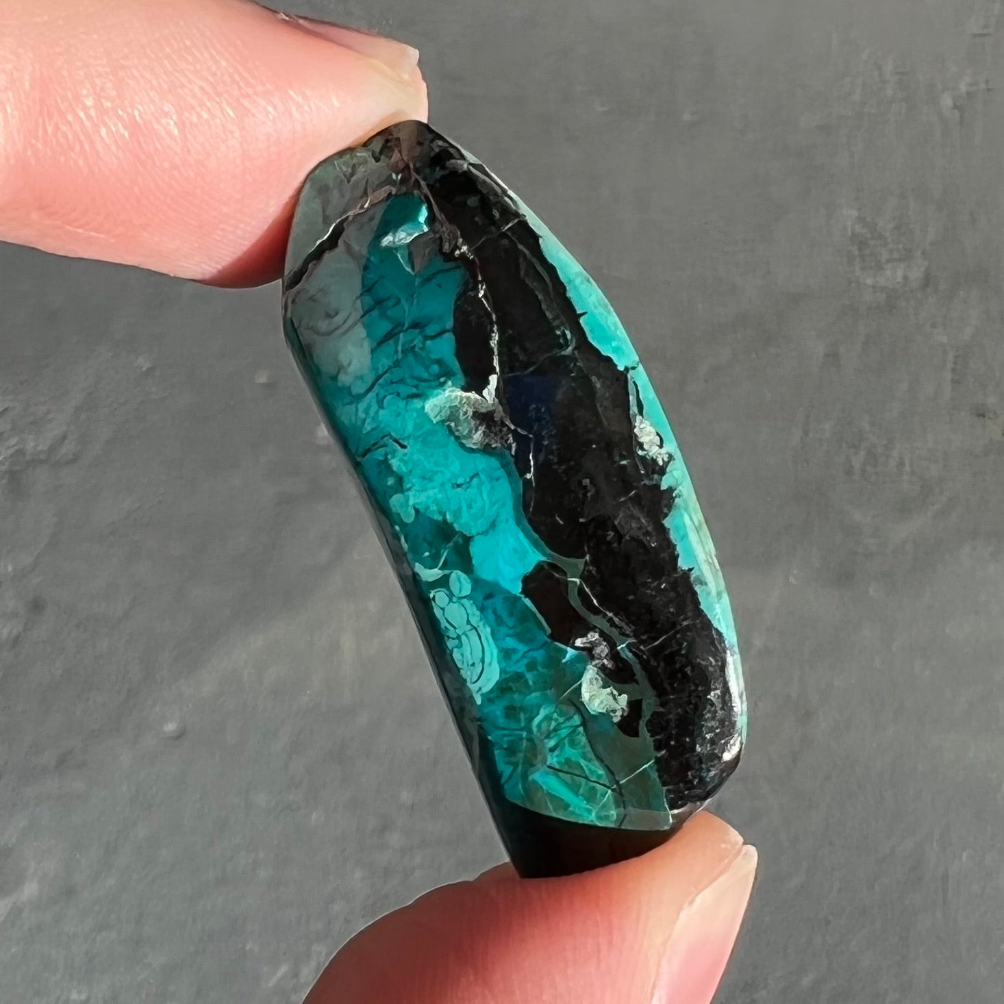 A loose chrysocolla stone with turquoise inclusions.