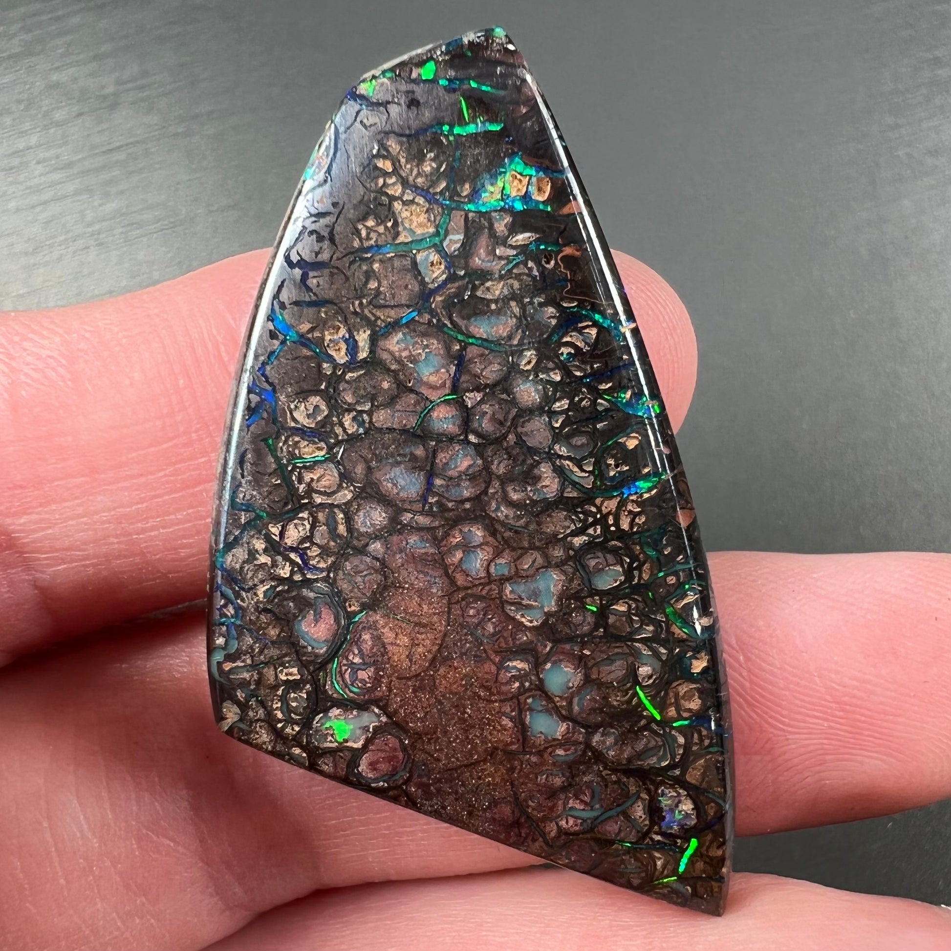 A loose, freeform cut polished Koroit boulder opal stone from Koroit Mining District, Australia.