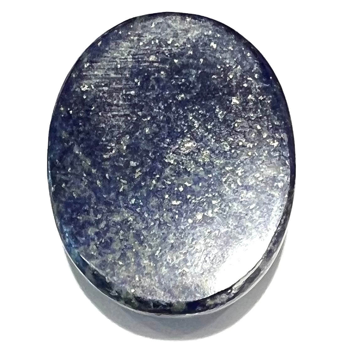 A loose, oval cabochon cut lapis lazuli stone.  A circle of pyrite inclusions is seen on the front.