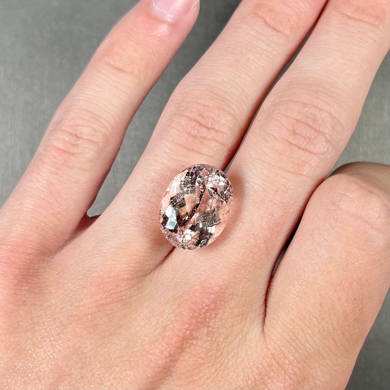 A loose, faceted oval cut pink morganite stone weighing over 14 carats.