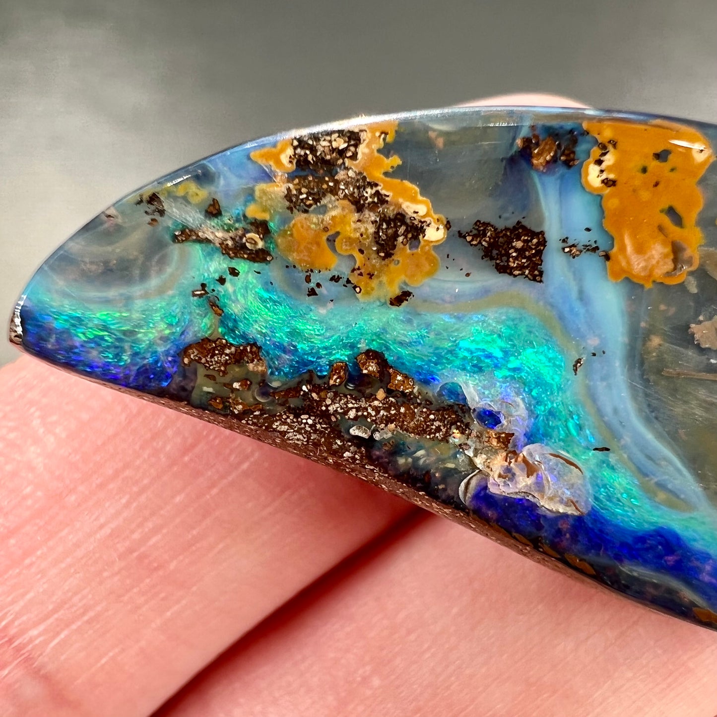 A freeform cut, loose black boulder opal stone from Queensland, Australia.