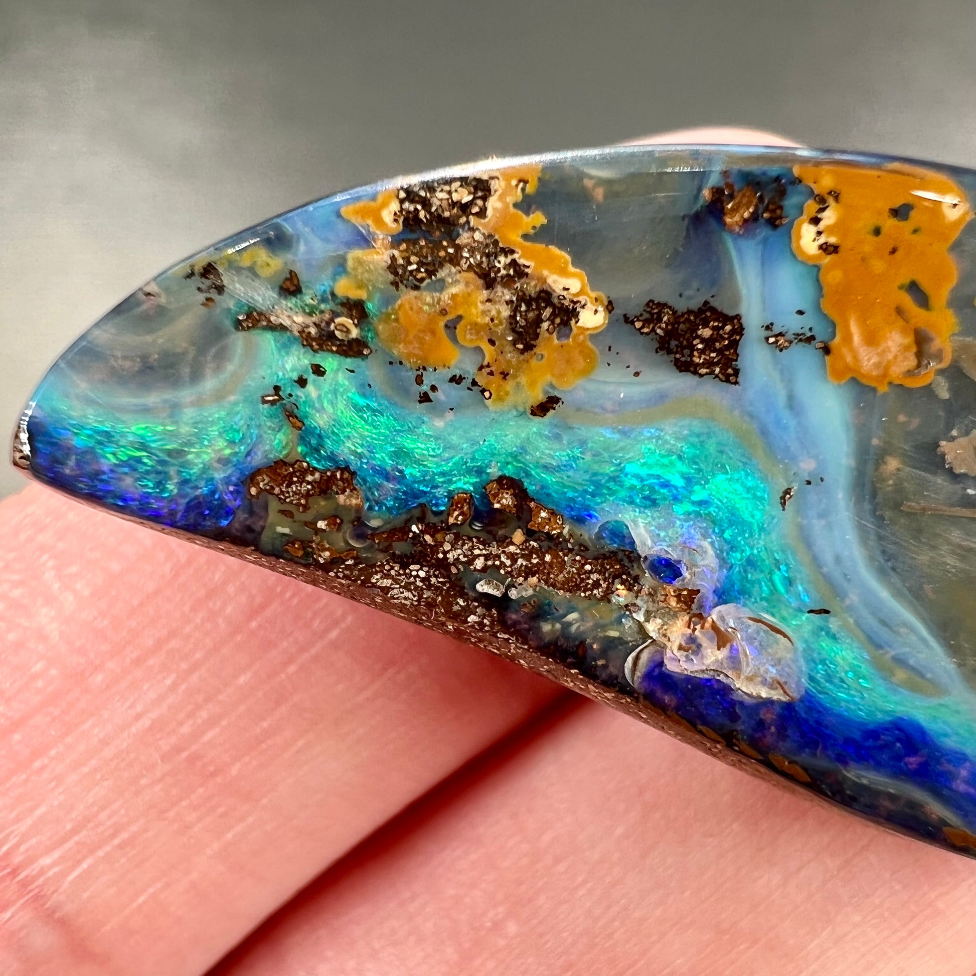 A freeform cut, loose black boulder opal stone from Queensland, Australia.