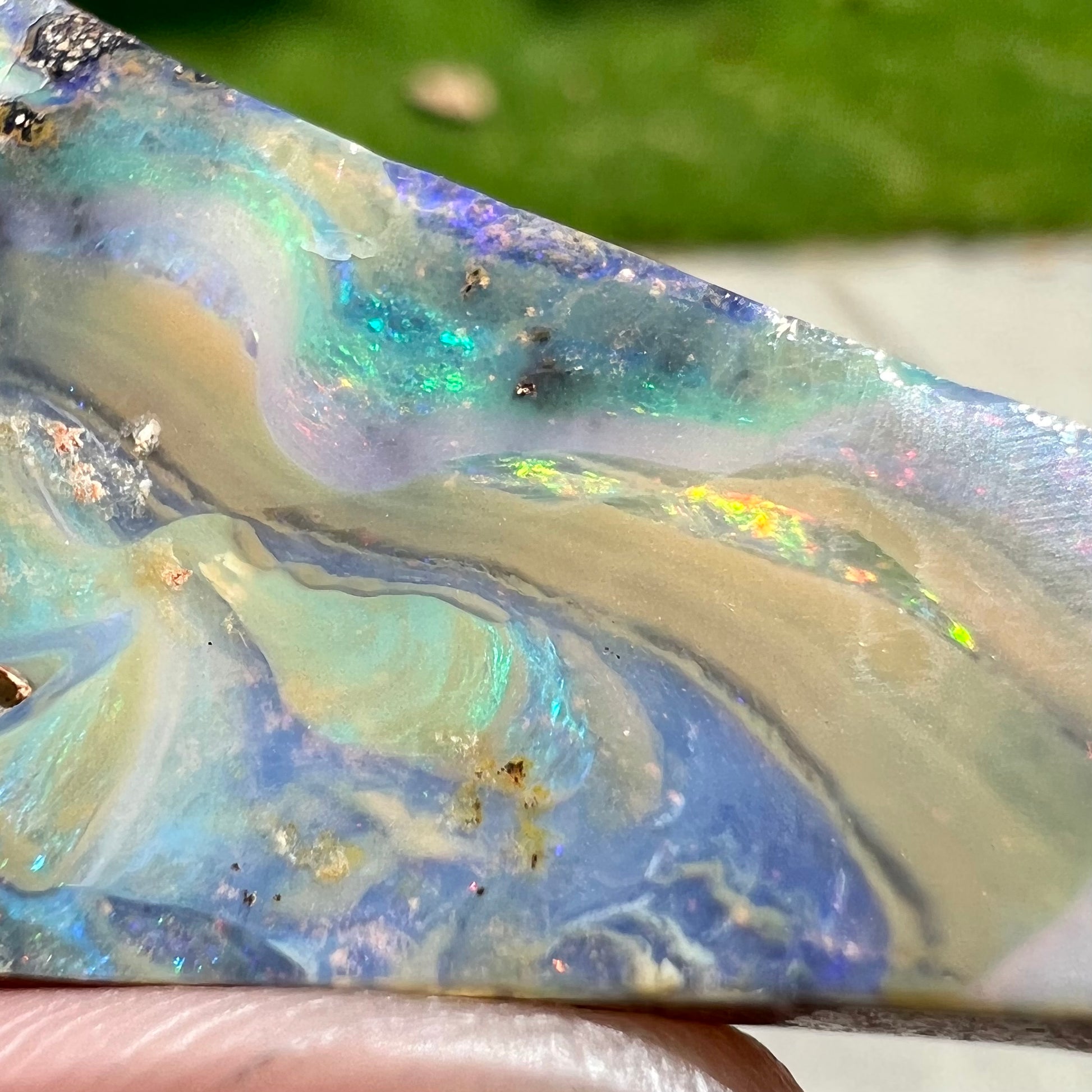 A loose, triangular shaped boulder opal stone from Queensland, Australia.