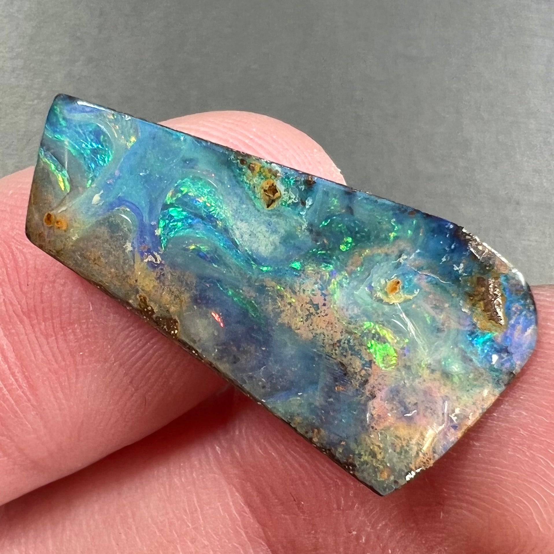 A loose, freeform cut boulder opal stone from Quilpie, Australia.