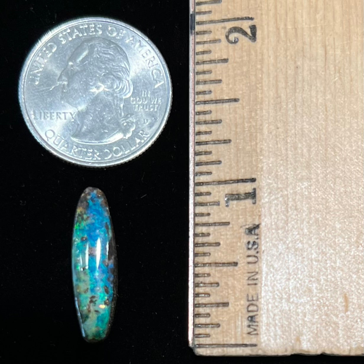 A loose, oval cabochon cut Australian boulder opal from Quilpie, Australia.  Predominant colors are blue and green.
