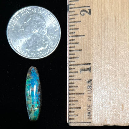 A loose, oval cabochon cut Australian boulder opal from Quilpie, Australia.  Predominant colors are blue and green.