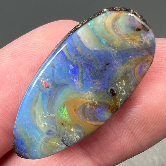 A loose, natural, pear shaped boulder opal stone from Quilpie, Australia.