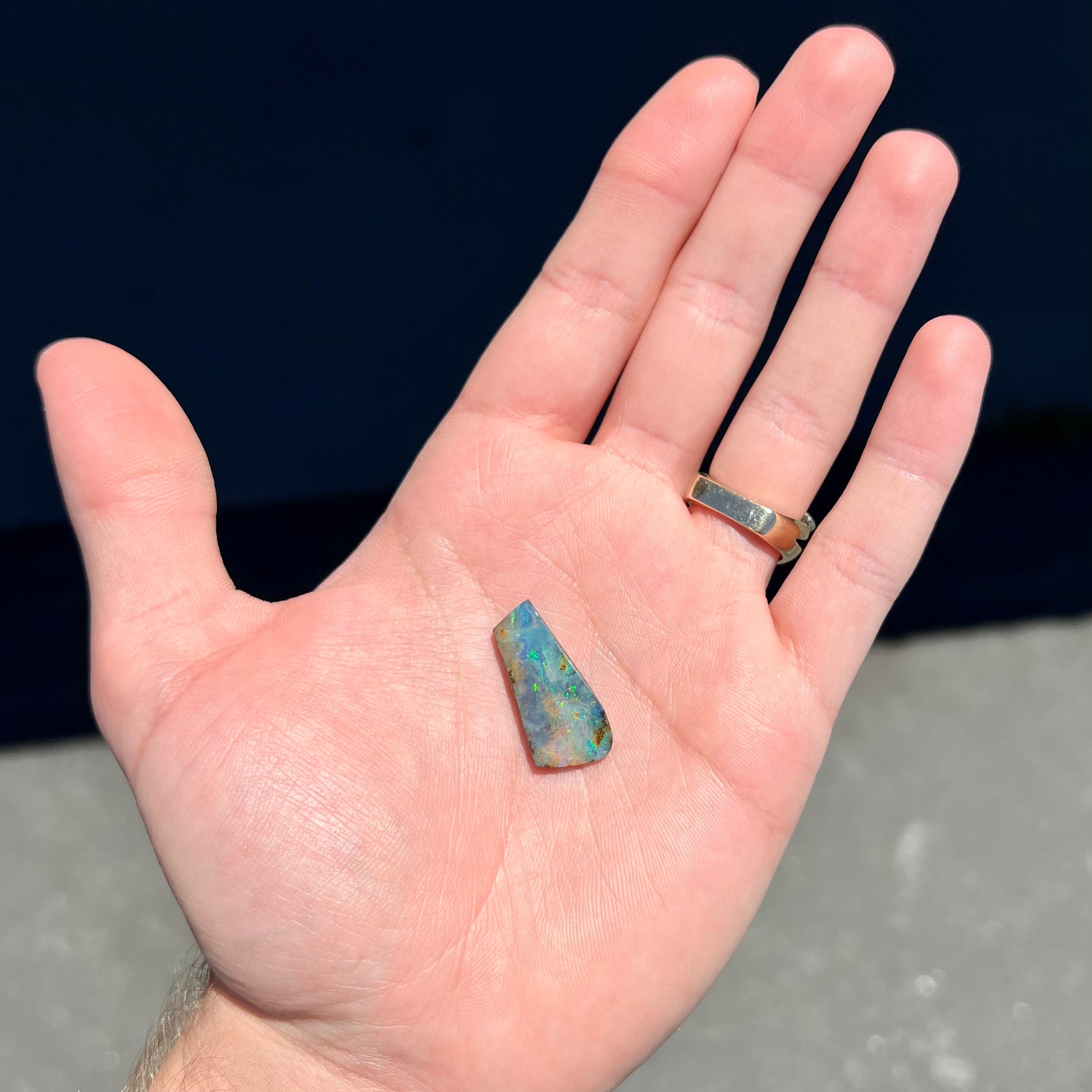 A loose, freeform cut boulder opal stone from Quilpie, Australia.