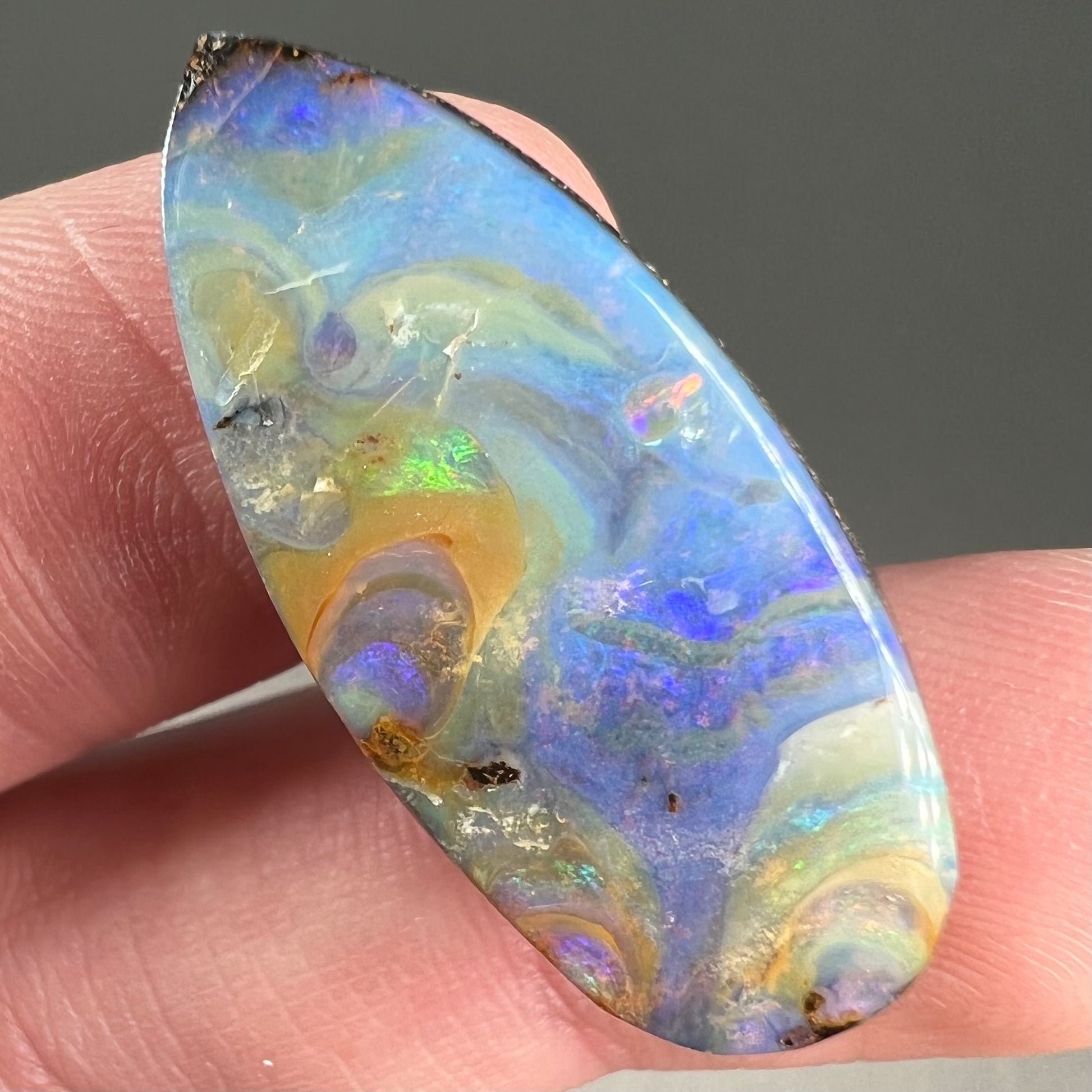 A loose, natural, pear shaped boulder opal stone from Quilpie, Australia.
