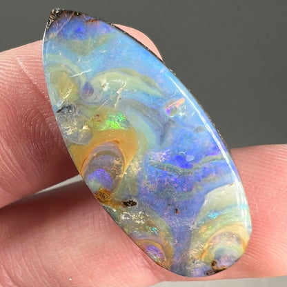 A loose, natural, pear shaped boulder opal stone from Quilpie, Australia.