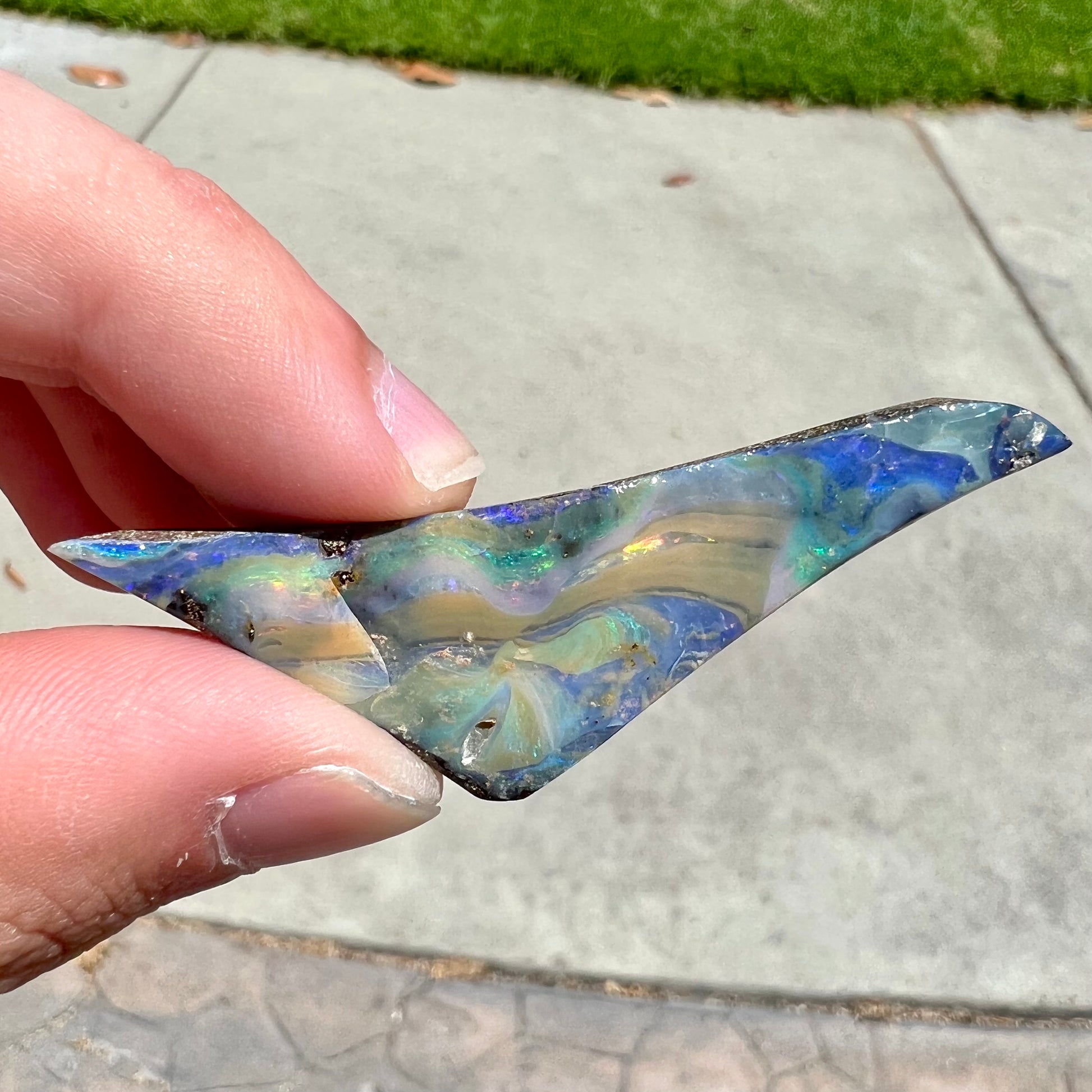 A loose, triangular shaped boulder opal stone from Queensland, Australia.