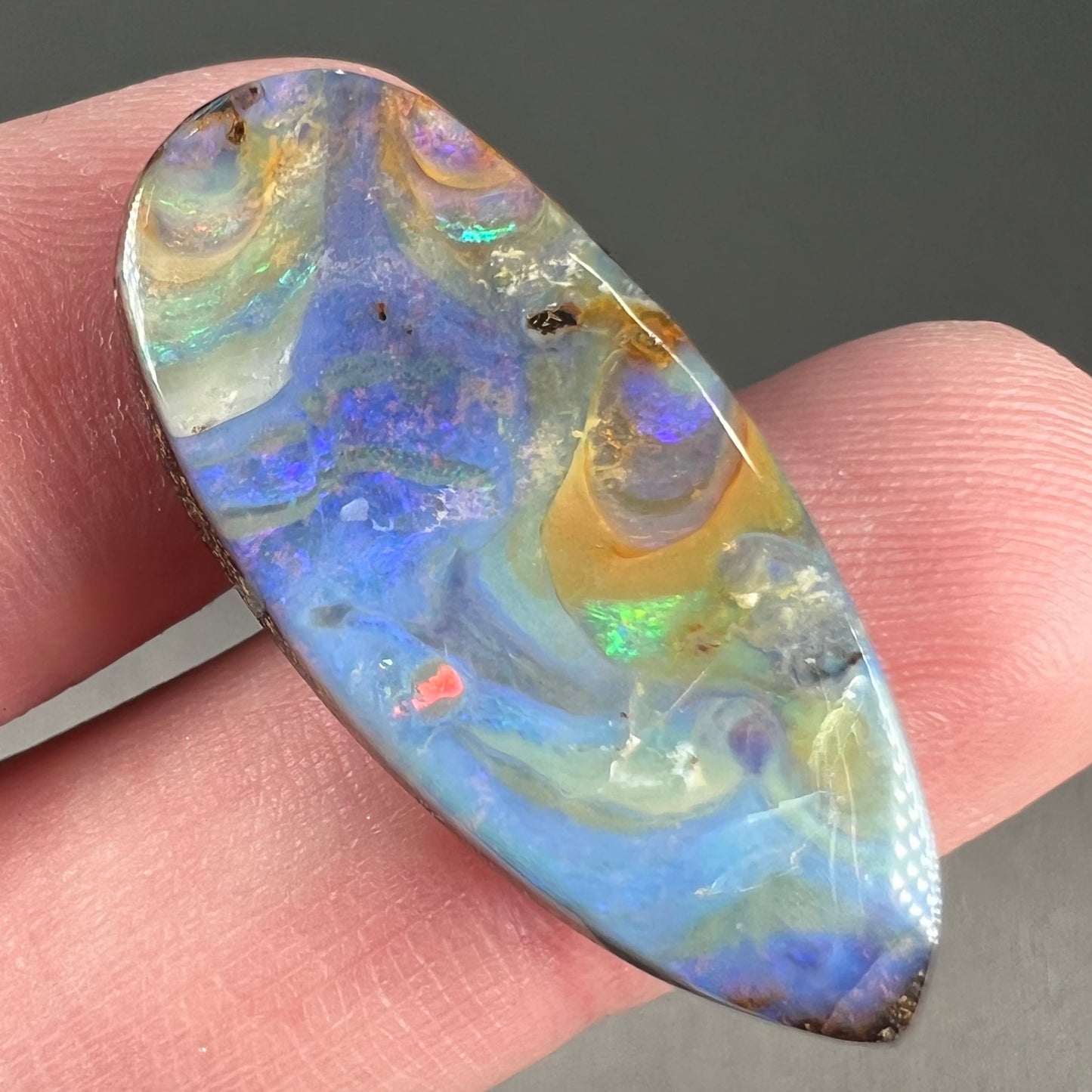 A loose, natural, pear shaped boulder opal stone from Quilpie, Australia.
