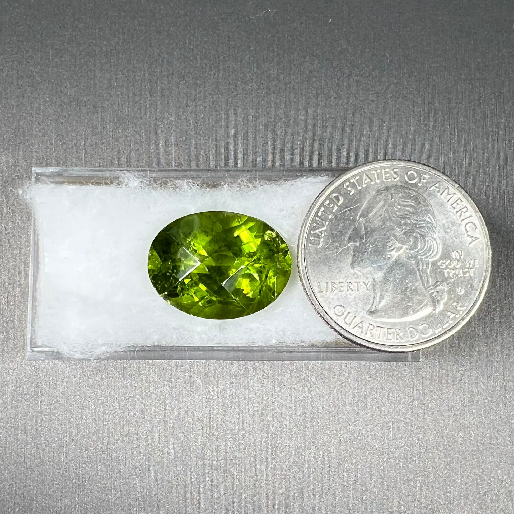 A loose, faceted oval checkerboard cut peridot gemstone from Pakistan.