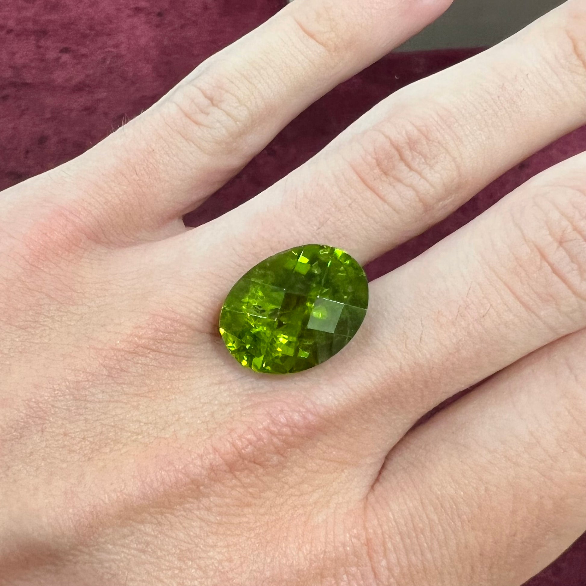 A loose, faceted oval checkerboard cut peridot gemstone from Pakistan.