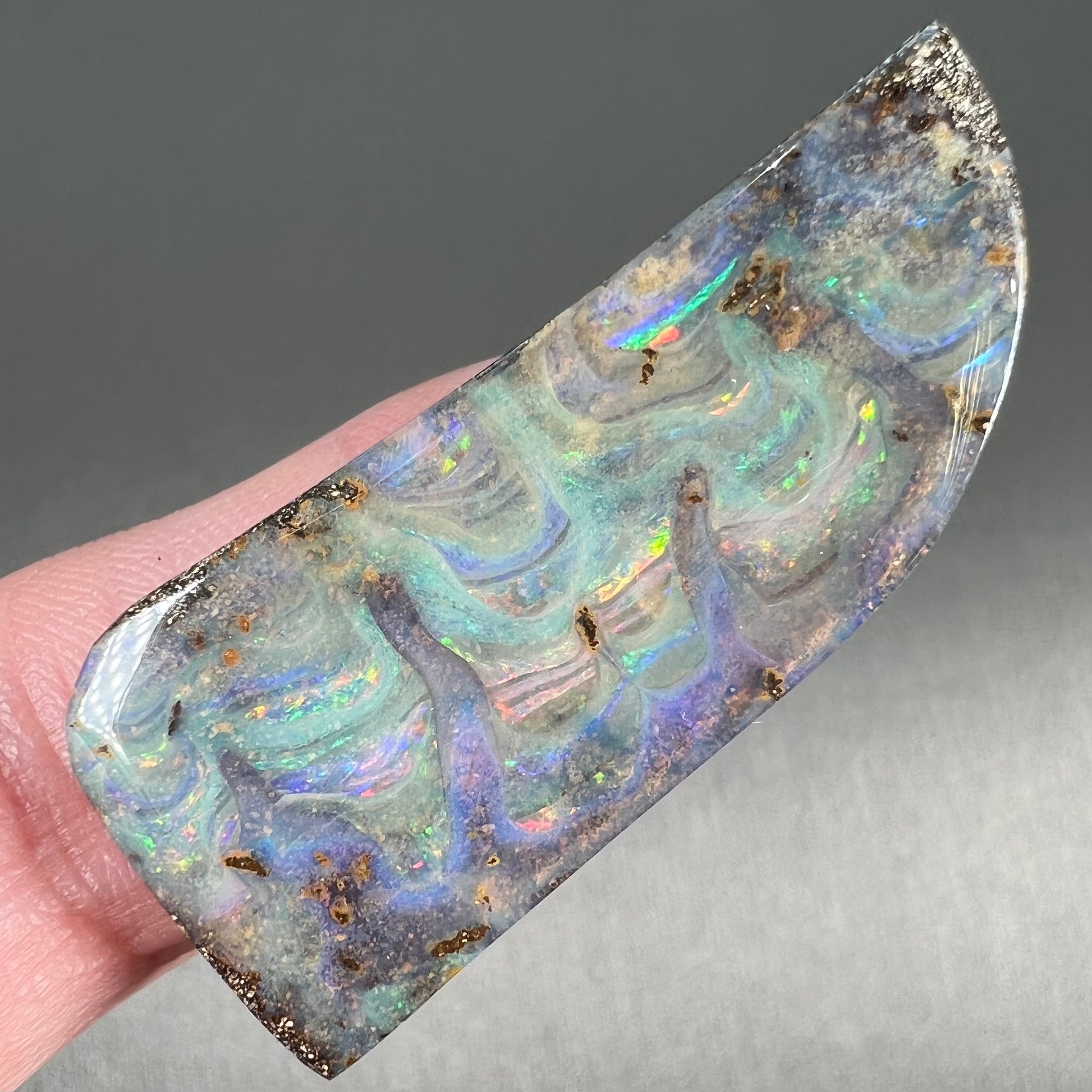 A loose, freeform cut, natural boulder opal stone from Quilpie, Australia.