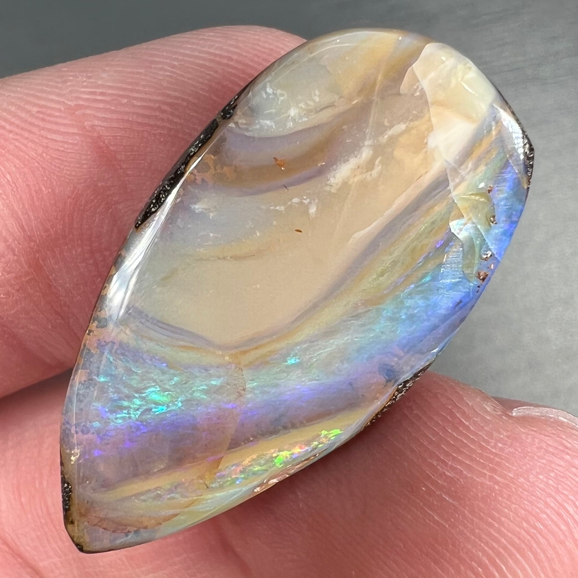 A loose, pear shaped cabochon cut boulder opal stone from Quilpie, Australia.