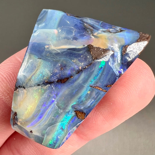 A loose, polished blue boulder opal specimen from Queensland, Australia.