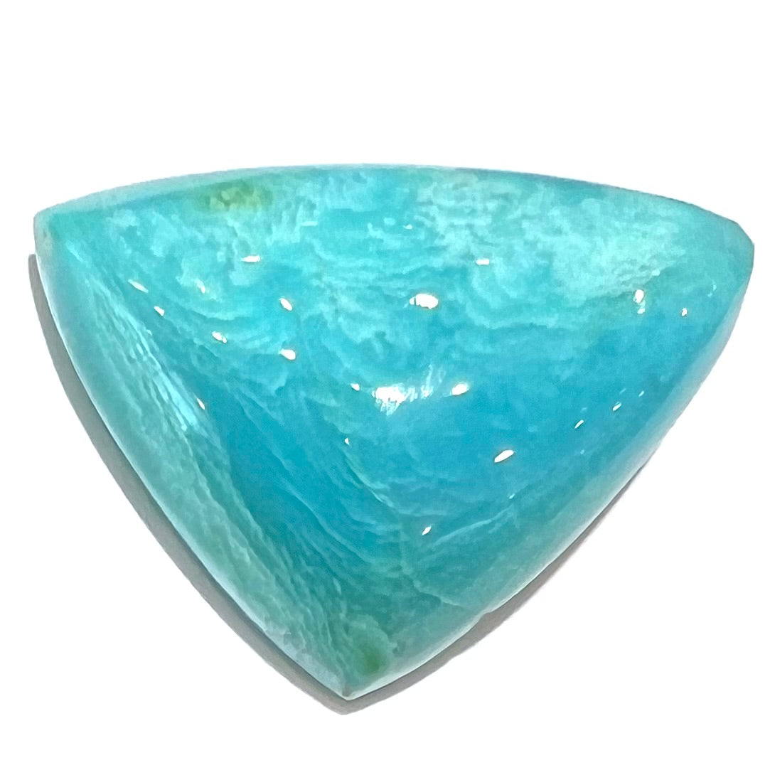 A loose triangular cabochon cut blue turquoise stone from the Sleeping Beauty Mine in Arizona.