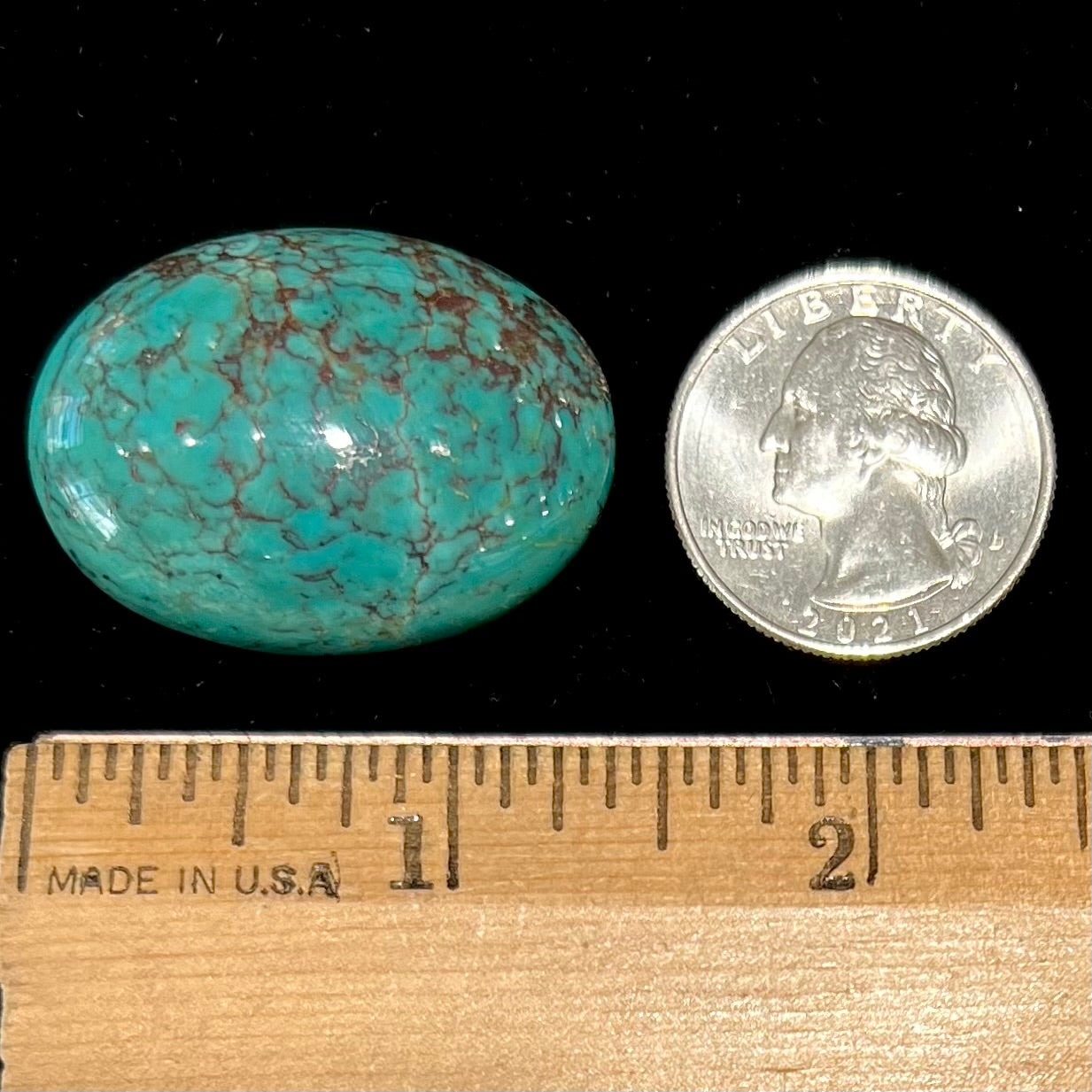 A loose, oval cabochon cut Tyrone turquoise stone.