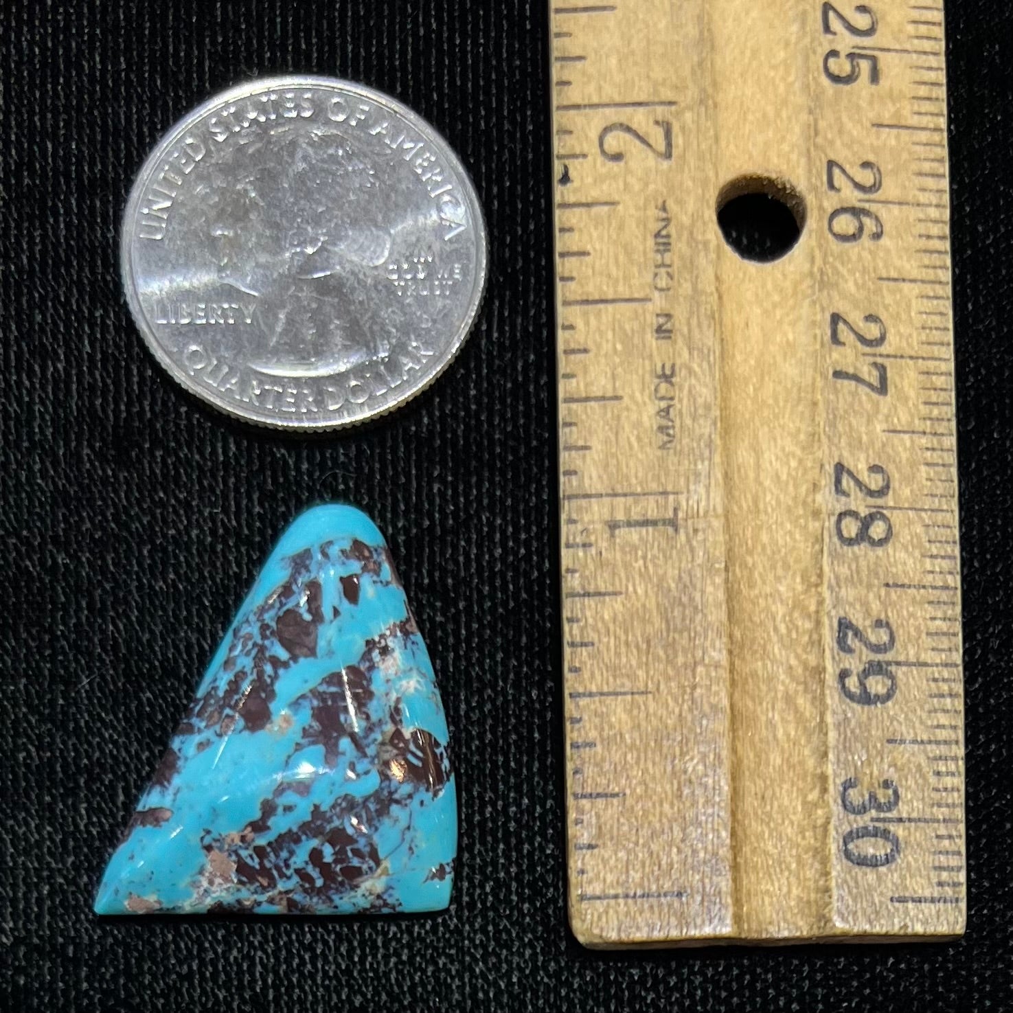 A triangular cabochon cut blue turquoise with red matrix from Mohave County, Arizona.