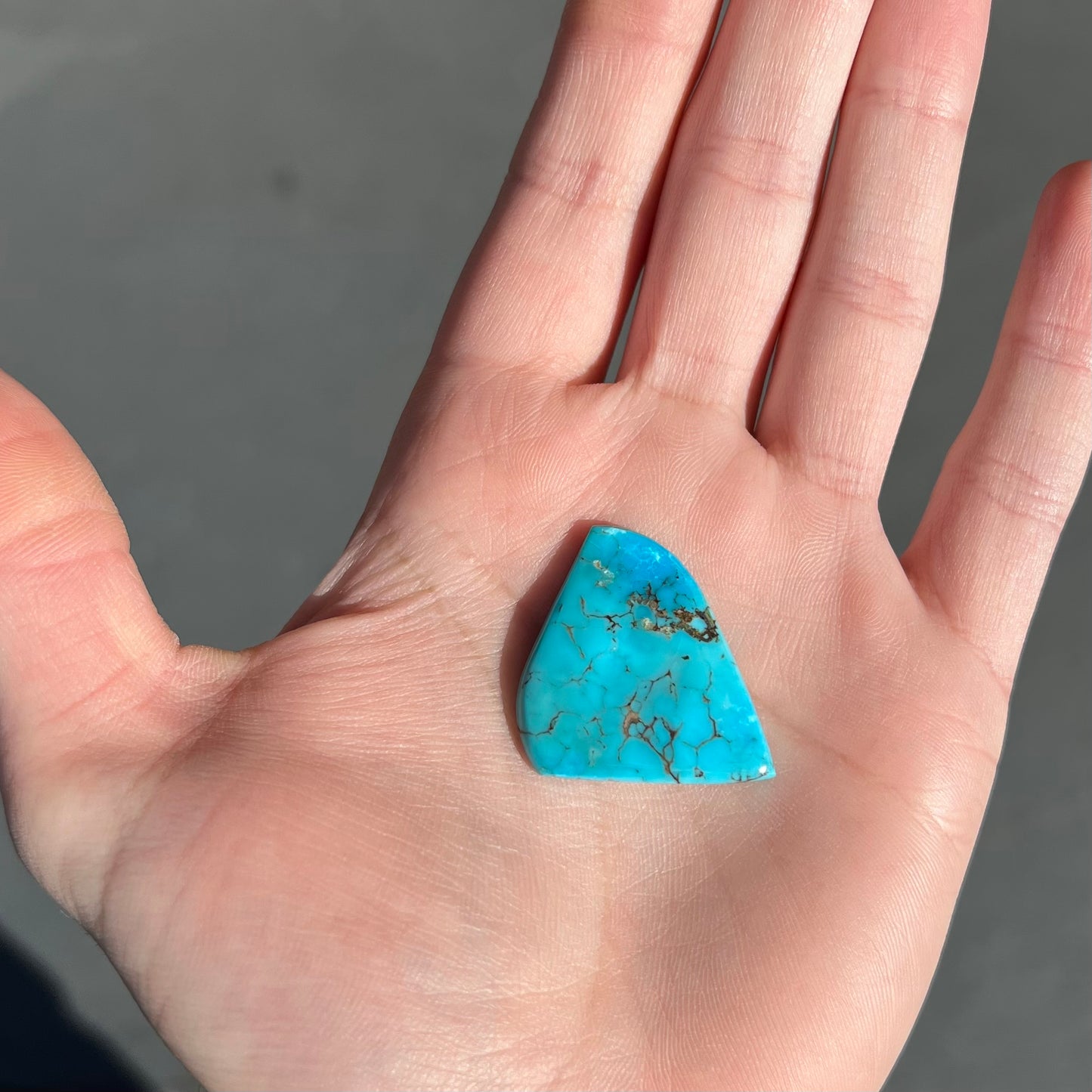 A loose, polished freeform piece of blue turquoise from the Sleeping Beauty Mine in Arizona.