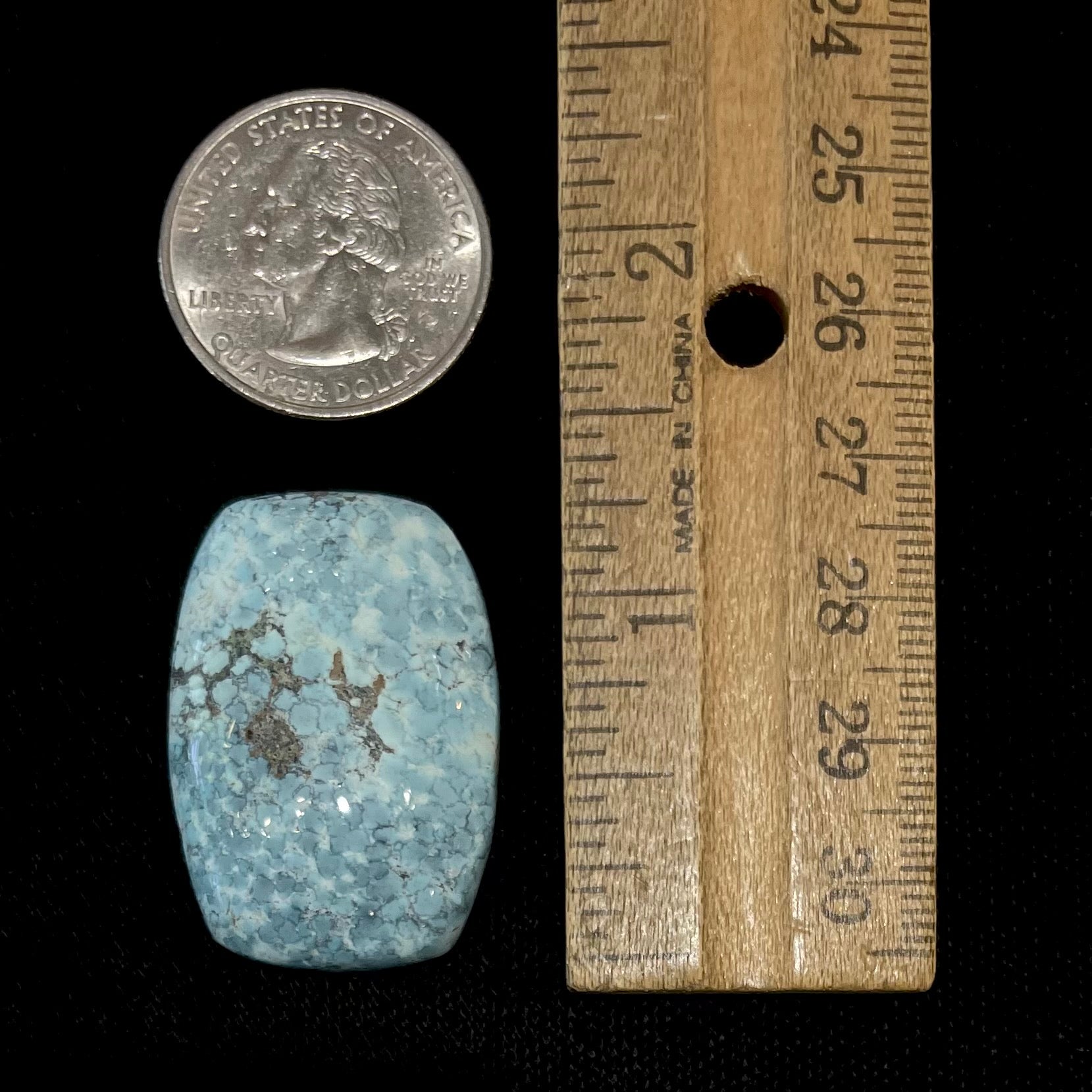 A loose, barrel cabochon cut turquoise stone from Baja California.  The piece is light blue with a gray matrix.