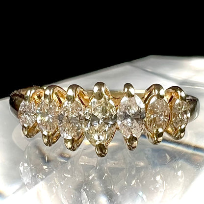 An estate yellow gold ring prong set with seven marquise cut diamonds.