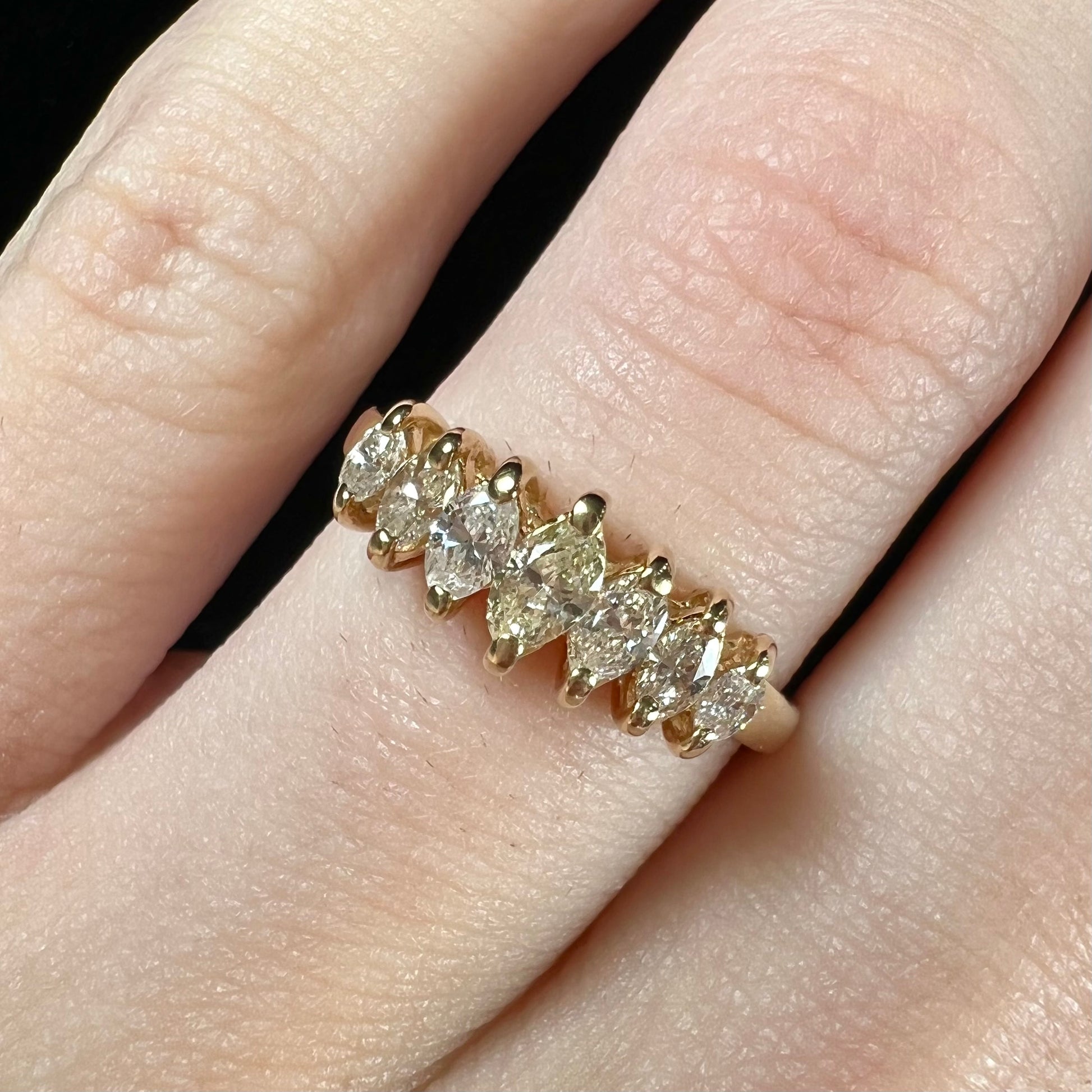 An estate yellow gold ring prong set with seven marquise cut diamonds.