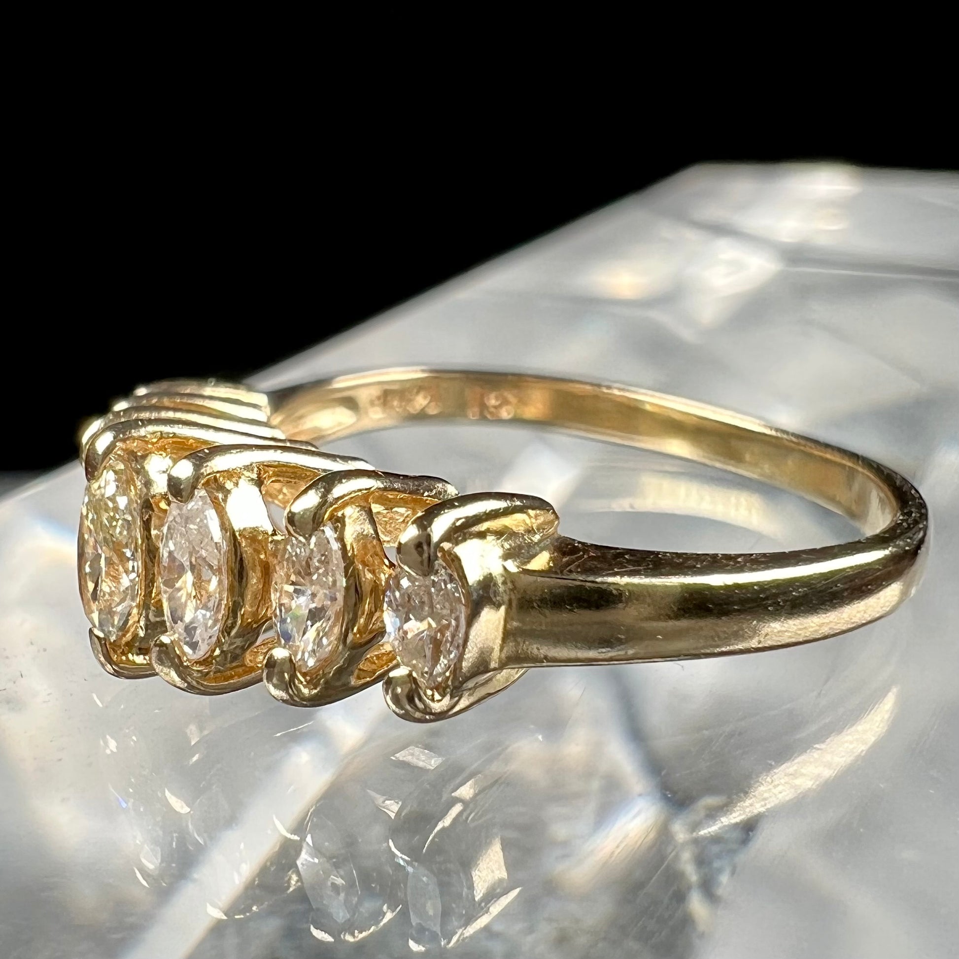 An estate yellow gold ring prong set with seven marquise cut diamonds.