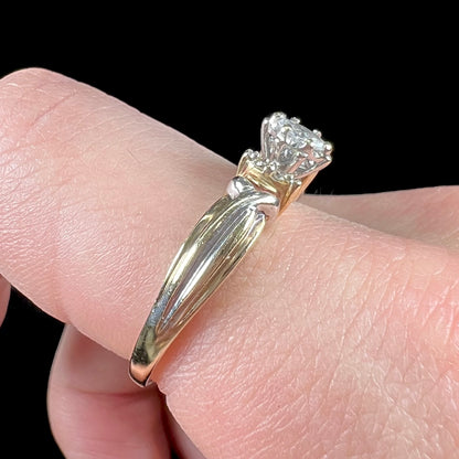 A ladies' two-tone white and yellow gold marquise cut diamond enagagement ring.  There are round diamond accents.