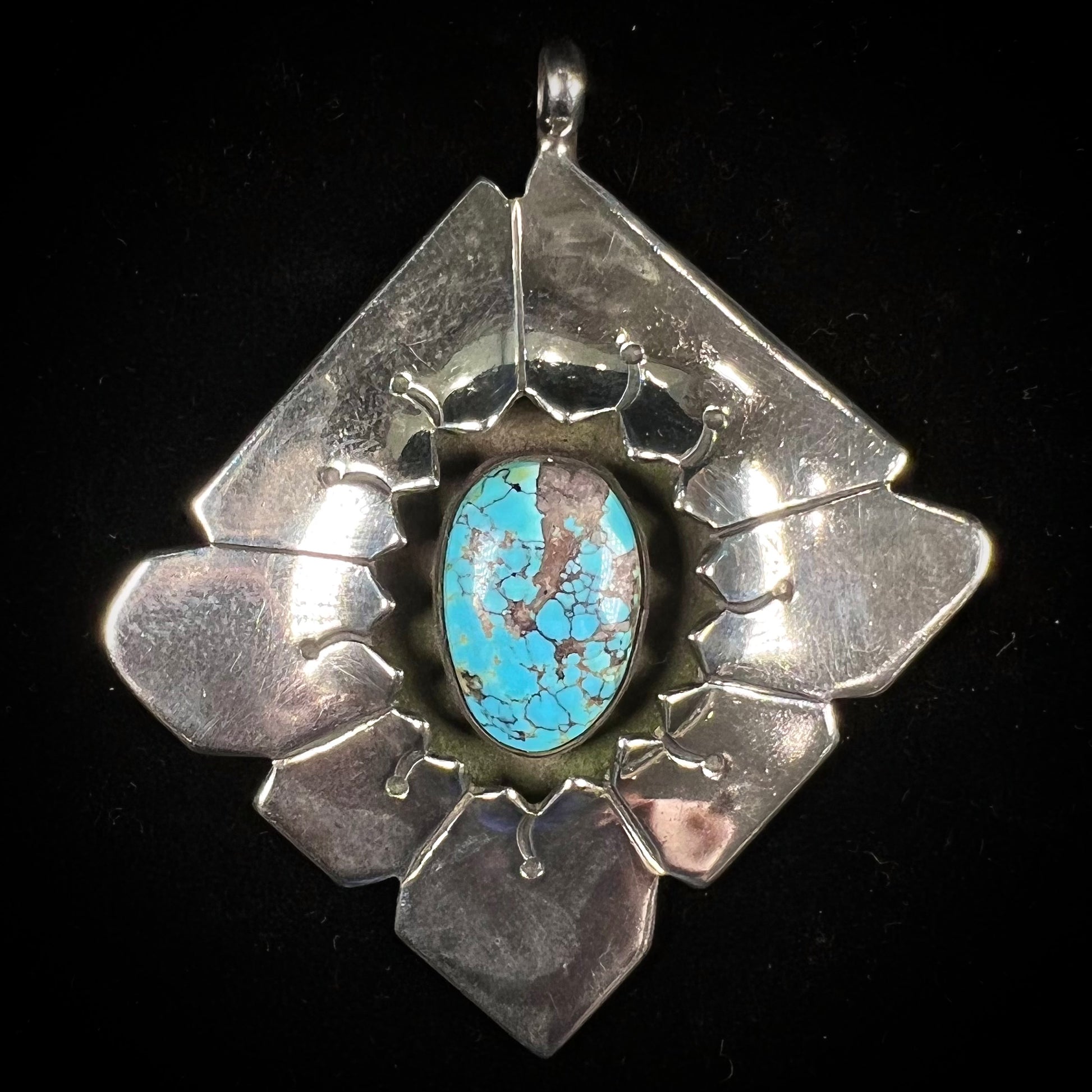 A handmade Mayan Indian pendant set with an oval cut turquoise stone from the Number 8 Mine.