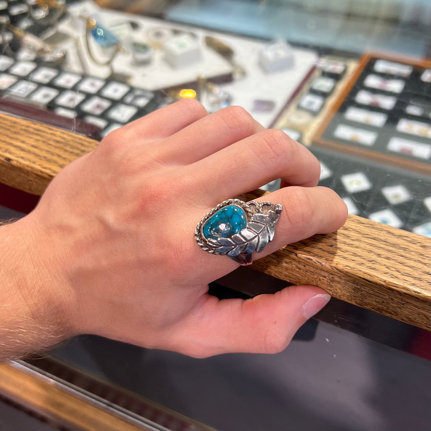 A handmade Navajo men's turquoise ring.  The ring is made with wire and carved silver.