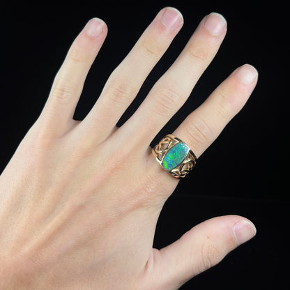 A men's natural Lightning Ridge, Australian black opal solitaire ring cast in yellow gold.