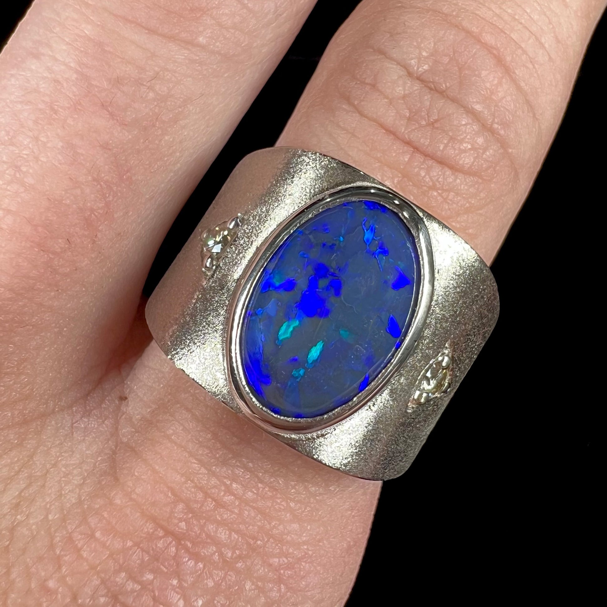 A men's natural black opal and diamond ring cast with a matte finish in white gold.