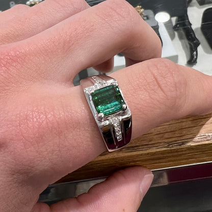 An 18k white gold green tourmaline and diamond men's ring.  The stones are princess cut.