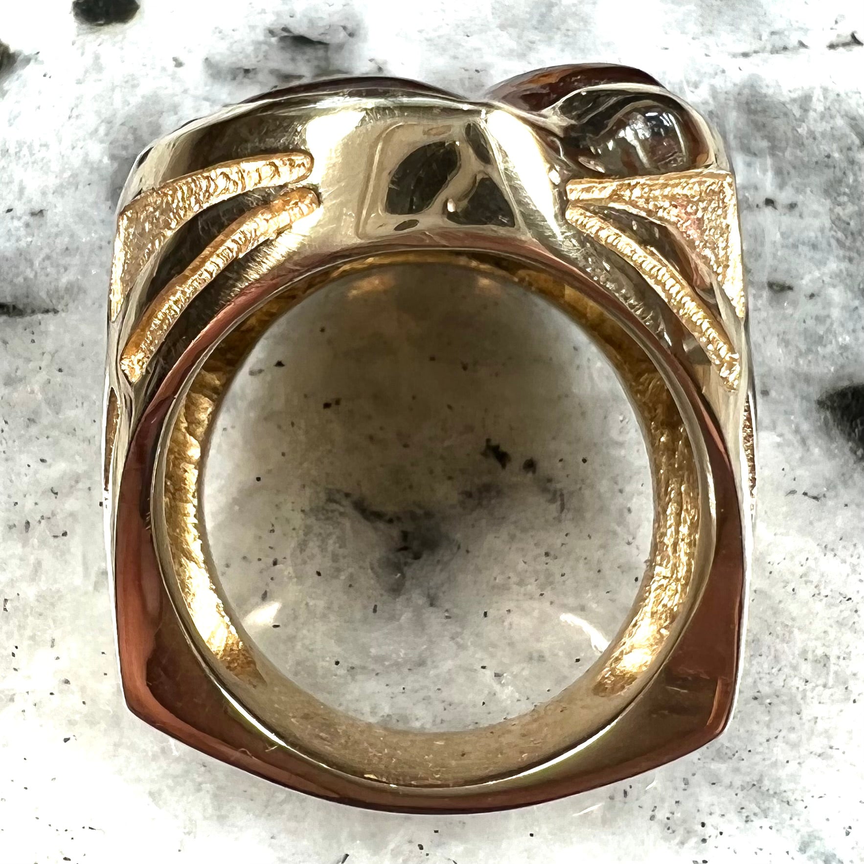 A yellow gold men's thug ring set with four fire agate stones resembling a spooky face.