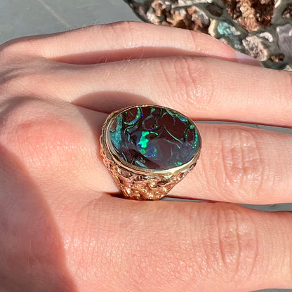 A men's yellow gold nugget style Koroit boulder opal solitaire ring.